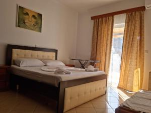 a bedroom with a large bed and a window at Alban Apartament in Lukovë +2 photos