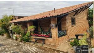 a house with a balcony with a table on it at Chalés de Tibau in Tibau