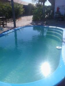 a large blue swimming pool with a frisbee in it at Chalés de Tibau in Tibau