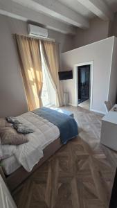 a bedroom with a large bed with a large window at Numistrano Room in Lamezia Terme