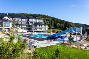 a resort with a swimming pool and a slide at Czarna Perła Apartamenty - bezpłatny basen - Czarna Góra Resort - Sienna in Sienna