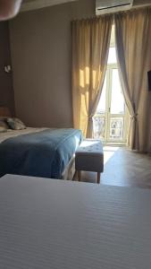 a bedroom with two beds and a window at Numistrano Room in Lamezia Terme