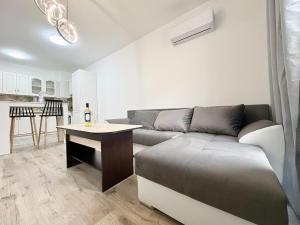 a living room with a couch and a table at Modern Nest Varna - free parking in Varna City