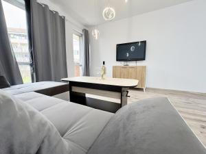 a living room with a couch and a tv at Modern Nest Varna - free parking in Varna City