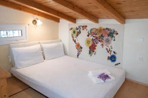 a white bed with a flower map on the wall at Sunshine Home - Peaceful Garden Escape & Parking in Selianitika