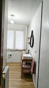 a white bathroom with a sink and a window at Casa Tía Maruja in Rianjo