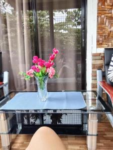 a vase of pink flowers sitting on a glass table at Laguerta Tahas House in Cebu City