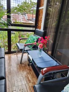 a table with a vase of flowers on a porch at Laguerta Tahas House in Cebu City