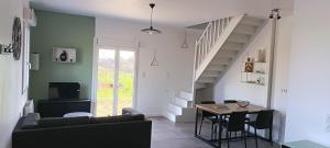 a living room with a couch and a table at Logement 1 - proche Le Mans in Aigné