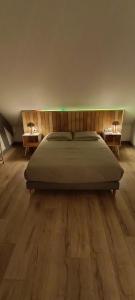 a bedroom with a bed with two nightstands and two tables at Logement 1 - proche Le Mans in Aigné