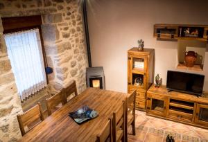 a dining room with a wooden table and a fireplace at Casa Rural el Meson in Fermoselle