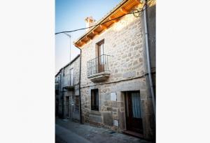 an old building with a balcony on a street at Casa Rural el Meson in Fermoselle