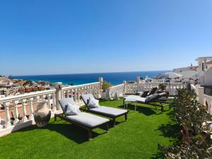a balcony with chairs and the ocean in the background at Apartamentos Alberto in Morro del Jable