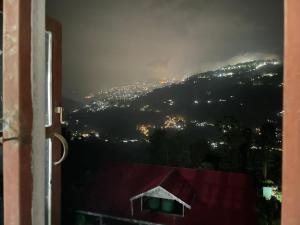 a view from a window of a city at night at Bagaicha Farms in Tādong
