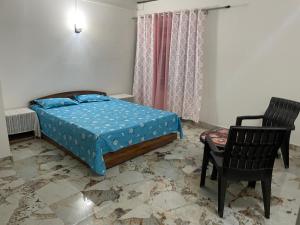 a bedroom with a bed and a chair at Bagaicha Farms in Tādong