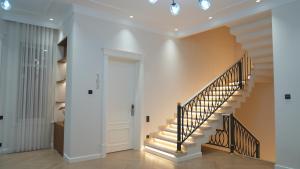a hallway with stairs in a home with white walls at Symphony Boutique in Tashkent