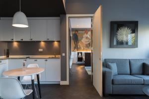 eine Küche und ein Wohnzimmer mit einem Sofa und einem Tisch in der Unterkunft B-aparthotel Kennedy in Den Haag
