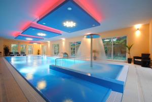 a large swimming pool in a building with a ceiling at Pensjonat Szajna Spa in Rymanów-Zdrój