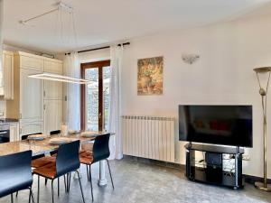a living room with a dining table and a flat screen tv at Terrazza fra lago e monti in Gravedona