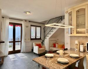 a kitchen and living room with a table and a staircase at Terrazza fra lago e monti in Gravedona