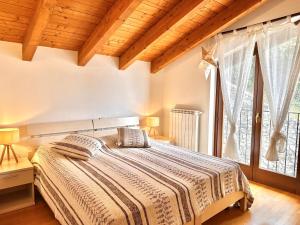 a bedroom with a bed and a large window at Terrazza fra lago e monti in Gravedona