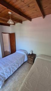 a bedroom with two beds and a wooden ceiling at La Mar in Mar de Ajó