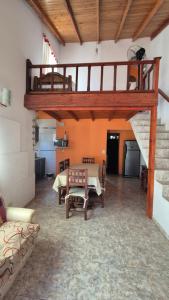 a living room with a staircase and a table and chairs at La Mar in Mar de Ajó