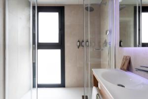a bathroom with a sink and a glass shower at Petit Palace Vargas in Seville +52 photos