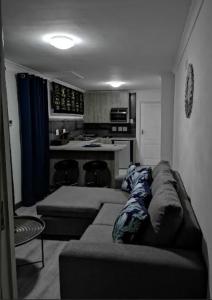 a living room with a couch and a kitchen at Memoirs in Cape Town in Zeekoevlei