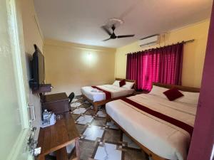 a hotel room with two beds and a tv at Hotel Lake shadow inn in Pokhara