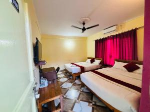 a hotel room with two beds and a tv at Hotel Lake shadow inn in Pokhara