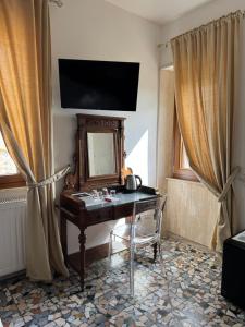 a room with a desk with a mirror and a television at Le Camere dei Magi in Saturnia