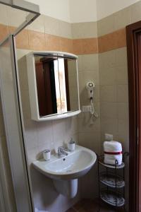 a bathroom with a sink and a mirror and towels at In Centro Holiday Home in Matera