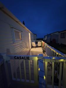 a house with a deck at night with lights at CASALIE at Seasalter Whitstable in Whitstable