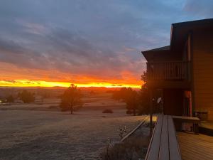 a sunset over a field with a house and a building at Bayou Hills BnB in Parker +4 photos
