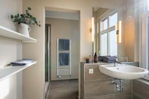 a bathroom with a sink and a shower with a mirror at Woge2 Appartement 7 in Borkum