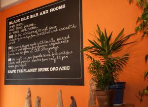 a menu on a wall with a potted plant at Black Isle Bar & Rooms in Inverness