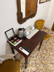a table with a mirror and a tea kettle on it at Le Camere dei Magi in Saturnia +28 photos