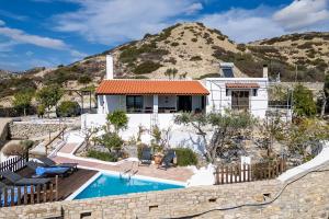 a house with a swimming pool in front of a mountain at The Retreat in Ierapetra