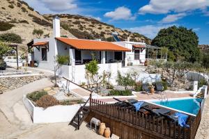 a house with a swimming pool and a mountain at The Retreat in Ierapetra