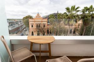 a table and chairs on a balcony with a view of a building at Petit Palace Vargas in Seville