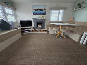 a living room with a couch and a table at CASALIE at Seasalter Whitstable in Whitstable +26 photos