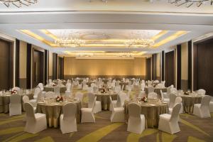 a banquet hall with tables and chairs and chandeliers at Radisson Blu Hotel Guwahati in Guwahati +179 photos