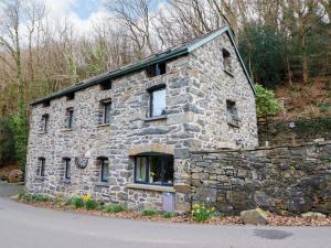 a stone building with windows on the side of a road at Millers Loft in Llanrwst
