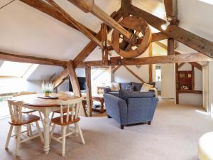 a living room with a table and a blue couch at Millers Loft in Llanrwst