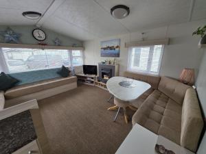a living room with a couch and a table at CASALIE at Seasalter Whitstable in Whitstable