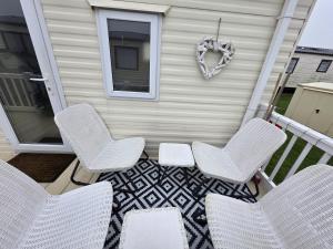 a patio with chairs and a heart wreath on a house at CASALIE at Seasalter Whitstable in Whitstable