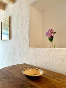 a bowl on a wooden table with a vase of flowers at Casa do Alva in Castelo de Vide +2 photos