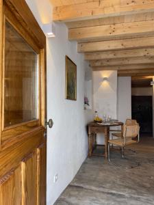 a room with a wooden door and a table with a chair at Casa do Alva in Castelo de Vide