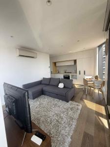 a living room with a couch and a tv at Cozy and Comfortable 2BR Apartment with master Ensuite and bathrooms in Melbourne